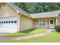 A single-story home with beige siding, attached two-car garage, and well-maintained yard at 7847 Dogwood Way, Douglasville, GA 30134
