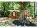 Charming brick home featuring a cozy front porch and beautiful landscaping around a mature tree at 2174 Rexford Dr, Decatur, GA 30034