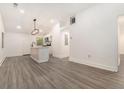 Open kitchen and living space with a white island and modern lighting at 2174 Rexford Dr, Decatur, GA 30034