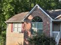 Close-up of a home's exterior showing red brick, a classic window, and a well-kept garden at 3230 Plymouth Rock Dr, Douglasville, GA 30135