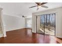 Bright living room with hardwood floors, ceiling fans, and a sliding glass door leading to outdoor space at 4870 Twin Lakes Trail, Atlanta, GA 30360