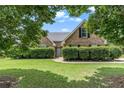 Charming brick home featuring symmetrical design, mature landscaping, and a well-maintained lawn at 1478 Elena Dr, Mcdonough, GA 30253