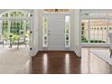 Sunlit foyer with hardwood floors flanked by formal spaces with large windows offering scenic views at 3600 Goldenrod Dr, Alpharetta, GA 30005