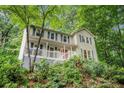 Inviting two-story home with a white porch and stairs surrounded by lush greenery at 507 Spring Creek Ne Way, Marietta, GA 30068