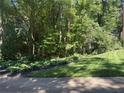 Well-manicured lawn and garden beds, nestled among mature trees, creating a private and peaceful outdoor space at 507 Spring Creek Ne Way, Marietta, GA 30068
