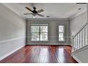 Open-concept living room with hardwood floors, large windows, and neutral paint at 3187 Mill Springs Cir, Buford, GA 30519