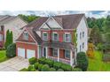 Lovely brick home with a cozy front porch, attached two-car garage, and lush, green landscaping at 5280 Lakerock Way, South Fulton, GA 30331