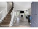 Open living room with a staircase, a fireplace, and durable wood-look flooring at 6279 Marbut Farms Rd, Lithonia, GA 30058