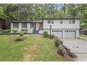 Well-maintained home featuring a white exterior, manicured lawn, and mature trees at 4760 Silverdale Rd, College Park, GA 30349