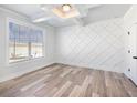 Bright bedroom featuring a decorative accent wall, modern ceiling and stylish wood flooring at 4437 Hosch Reserve Ct, Buford, GA 30519