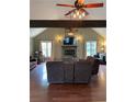 Inviting living room features a stone fireplace, ceiling fan, hardwood floors, and plenty of natural light at 17 Country Walk, Cartersville, GA 30121