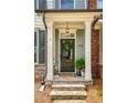 Inviting entryway with a decorated door, stone steps, and a classic hanging lantern at 239 S Village Sq, Canton, GA 30115