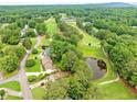 Breathtaking aerial view of a home near a lush golf course, a serene pond, and tree-lined streets at 12162 Mountain Laurel Dr, Roswell, GA 30075
