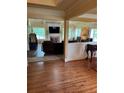 Spacious living room showcasing hardwood floors, fireplace, large TV, and open layout to dining area at 12162 Mountain Laurel Dr, Roswell, GA 30075