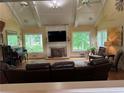 Bright living room with vaulted ceilings, fireplace, hardwood floors, and multiple windows offering scenic views at 12162 Mountain Laurel Dr, Roswell, GA 30075