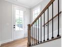 Bright entryway with hardwood floors, staircase, and natural light streaming through the front door at 206 Grady Burrell Dr, Holly Springs, GA 30115