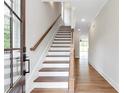 Bright entryway with hardwood floors, staircase, and natural light streaming through the front door at 206 Grady Burrell Dr, Holly Springs, GA 30115