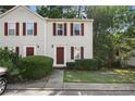 Charming townhouse with red shutters, complemented by a well-maintained front lawn and mature trees, conveniently located near parking at 3371 Spring Harbour Dr, Atlanta, GA 30340