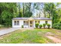 Charming single story home with neutral paint, manicured shrubs, and a lovely walkway leading to the front door at 398 Baker Nw Cir, Atlanta, GA 30318