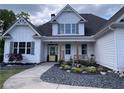 Inviting home featuring a cozy porch with a swing and decorative landscaping at 605 Red Leaf Way, Canton, GA 30114