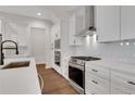 Well-equipped kitchen boasts white cabinets, stainless steel appliances, and sleek countertops with modern fixtures at 118 Via Roma, Woodstock, GA 30188