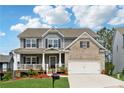 Charming two-story home featuring a welcoming front porch, brick accents, and well-manicured lawn at 211 Serendipity Way, Dallas, GA 30157