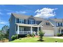 Charming two-story home featuring a welcoming front porch, brick accents, and well-manicured lawn at 211 Serendipity Way, Dallas, GA 30157