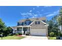 Charming two-story home with a welcoming front porch, two-car garage, landscaped yard and gray and brick exterior at 211 Serendipity Way, Dallas, GA 30157