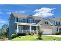 Charming two-story home with a welcoming front porch, two-car garage, landscaped yard and gray and brick exterior at 211 Serendipity Way, Dallas, GA 30157