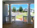 Inviting front porch featuring white columns and railings offering a pleasant view of the neighborhood at 211 Serendipity Way, Dallas, GA 30157