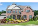 Beautiful brick home offers refined details, a lush lawn, and colorful, manicured landscaping at 431 La Perla Dr, Sugar Hill, GA 30518