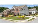 Spacious two-story home with attached garage, lush front lawn, and colorful manicured landscaping at 431 La Perla Dr, Sugar Hill, GA 30518
