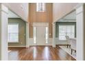 Spacious foyer with hardwood floors and elegant columns leading to the dining area at 5115 Amberden Hall Dr, Suwanee, GA 30024