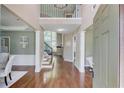 Grand foyer with hardwood floors, a staircase, and natural light from the large windows at 5115 Amberden Hall Dr, Suwanee, GA 30024