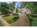 Beautifully landscaped front yard leading up to a stately two-story brick home at 8630 Moor Park Run, Duluth, GA 30097