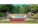 Community entrance sign for Tributary with stone pillars surrounded by colorful flowers and lush greenery at 9990 Blackfriars Rd, Douglasville, GA 30135