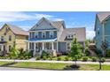 Charming two-story home featuring a welcoming front porch, lush lawn, and mature landscaping at 9990 Blackfriars Rd, Douglasville, GA 30135