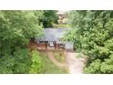 Overhead shot of a gray, brick accented home surrounded by mature trees and lush greenery at 4339 Sasanqua Ct, Tucker, GA 30084