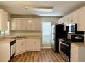 Well-lit kitchen featuring wood floors, light-colored cabinets, and stainless steel appliances at 5105 N Bridges Dr, Alpharetta, GA 30022