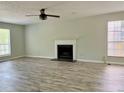 Open living room with modern fireplace, ceiling fan, and large windows at 5105 N Bridges Dr, Alpharetta, GA 30022