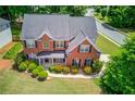Stunning aerial view of a brick home with a manicured lawn and a lush green surrounding at 1657 Hampton Woods Way, Lawrenceville, GA 30043
