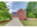 Side view of a brick home featuring an attached garage and a well-maintained yard at 1657 Hampton Woods Way, Lawrenceville, GA 30043