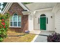 Up close exterior view of a charming home with a green front door, beautiful brick and siding at 1978 Elmwood Cir, Snellville, GA 30078