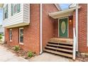 Close-up of the entrance to the house with a dark green front door and wooden stairs at 524 Stephens Point Se Dr, Lawrenceville, GA 30045