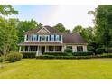 Traditional two-story home with a welcoming front porch and lush green lawn at 8601 Flint Hill Rd, Douglasville, GA 30135