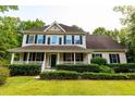 Charming two-story home featuring a covered front porch and manicured hedges at 8601 Flint Hill Rd, Douglasville, GA 30135