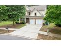 Attractive two-story home boasts a lush front yard, double garage, and beautiful landscaping at 1029 Harvest Brook Dr, Lawrenceville, GA 30043
