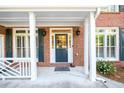 Charming covered front porch featuring a brick facade and painted columns at 1304 Carrington Way, Lawrenceville, GA 30044