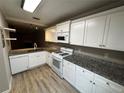 Bright kitchen with white cabinets, granite countertops, modern appliances, and stylish flooring at 351 Oak Harbor Trl, Marietta, GA 30066