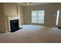 Inviting living room features a fireplace, ample natural light from a large window and adjacent entry door at 2858 Parkway Close, Lithonia, GA 30058
